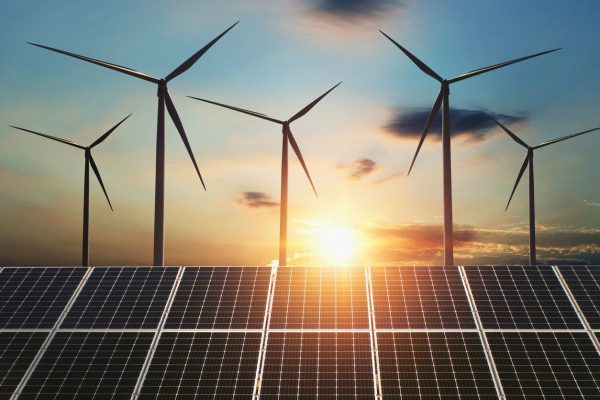 concept clean energy. wind turbine and solar panel in sunrise background